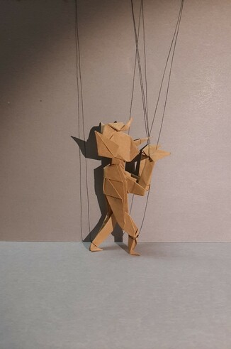 Modello origami di Pinocchio, con le orecchie d'asino e i fili da burattino.