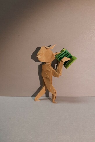 Modello origami di Pinocchio (senza orecchie da somaro e senza fili da burattino) che legge un libro.
