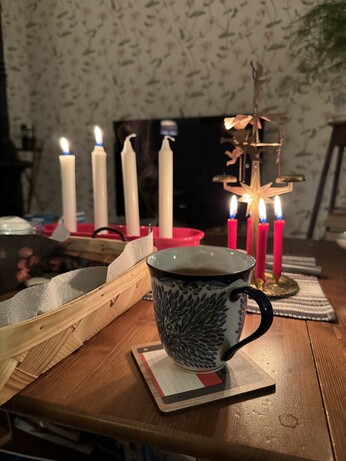Andra advent. Två ljus tända, ett änglaspel och en kopp med te.