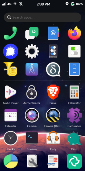 The image shows a Librem 5 Linux smartphone home screen with a dark background featuring a starry space theme. At the top, there is a status bar displaying the time as 2:39 PM, 4G connectivity, Wi-Fi, Bluetooth turned off, and a battery level of 84%. Below the status bar, there is a search bar with the text "Search apps..." in gray.

The home screen is organised into a grid of app icons. The 1st row includes a green phone icon, a green messaging icon, a blue book icon with "@" symbol, and a Firefox browser icon. 

The 2nd row features a blue Signal Messenger icon, a gear settings icon, a smartphone icon with toggle switches, 

The 3rd row features a tuba musical instrument icon, a radio tower broadcast icon, a chat bubble icon with a "d" which looks like and upside down and inverted "g" (opposite of #Google?), and a blue file drawer icon. 

The 4th row includes an audio player icon, a timing lock icon, a lion face Brave browser icon, and a calculator icon. 

The 5th row shows a calendar icon, a camera icon, a camera under construction icon, and a carburetor icon. 

The 6th row includes a clocks icon, a terminal icon, a headphones over book (audiobook) icon, and a dinosaur icon. 

The 7th row features a pie chart icon, a wrench over hard disk icon, a document with eyeglasses icon, and a green circular icon with a white swirl.

Provided by @altbot, edited. Missed by altbot: The bottom of the starry space-themed wallpaper shows the top of a Mars-like sandy planet.