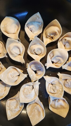 Hat-shaped dumplings on a pan ready to be steamed