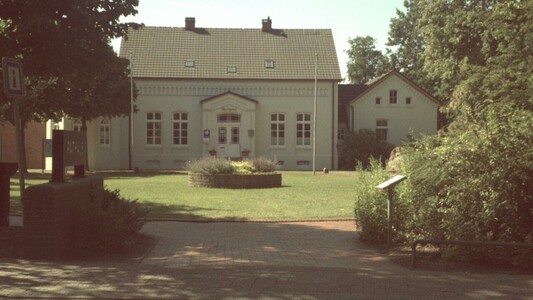 Photo of a building with a nice garden in front