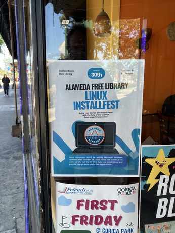 Photo of a taqueria front window with flyers taped to it, including one for "Alameda Free Library Linux Installfest"
