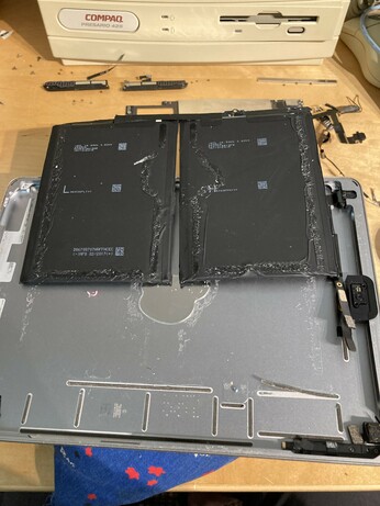 A battery removed from the iPad 5, showing glue bits left all over the casing. The entire ipad has been stripped down to its skeleton just to remove the battery.